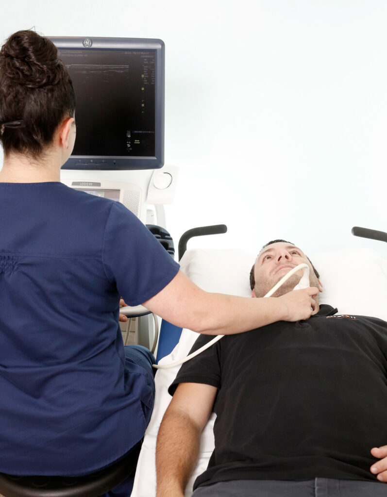 Radiologist performing diagnostic ultrasound on male patient